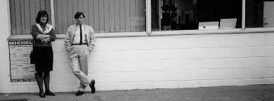 Two people leaning against a wall